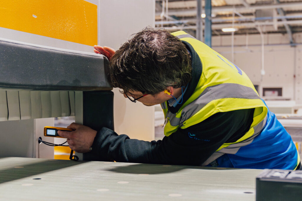 Engineer verifying guarding reach distances during a PUWER assessment